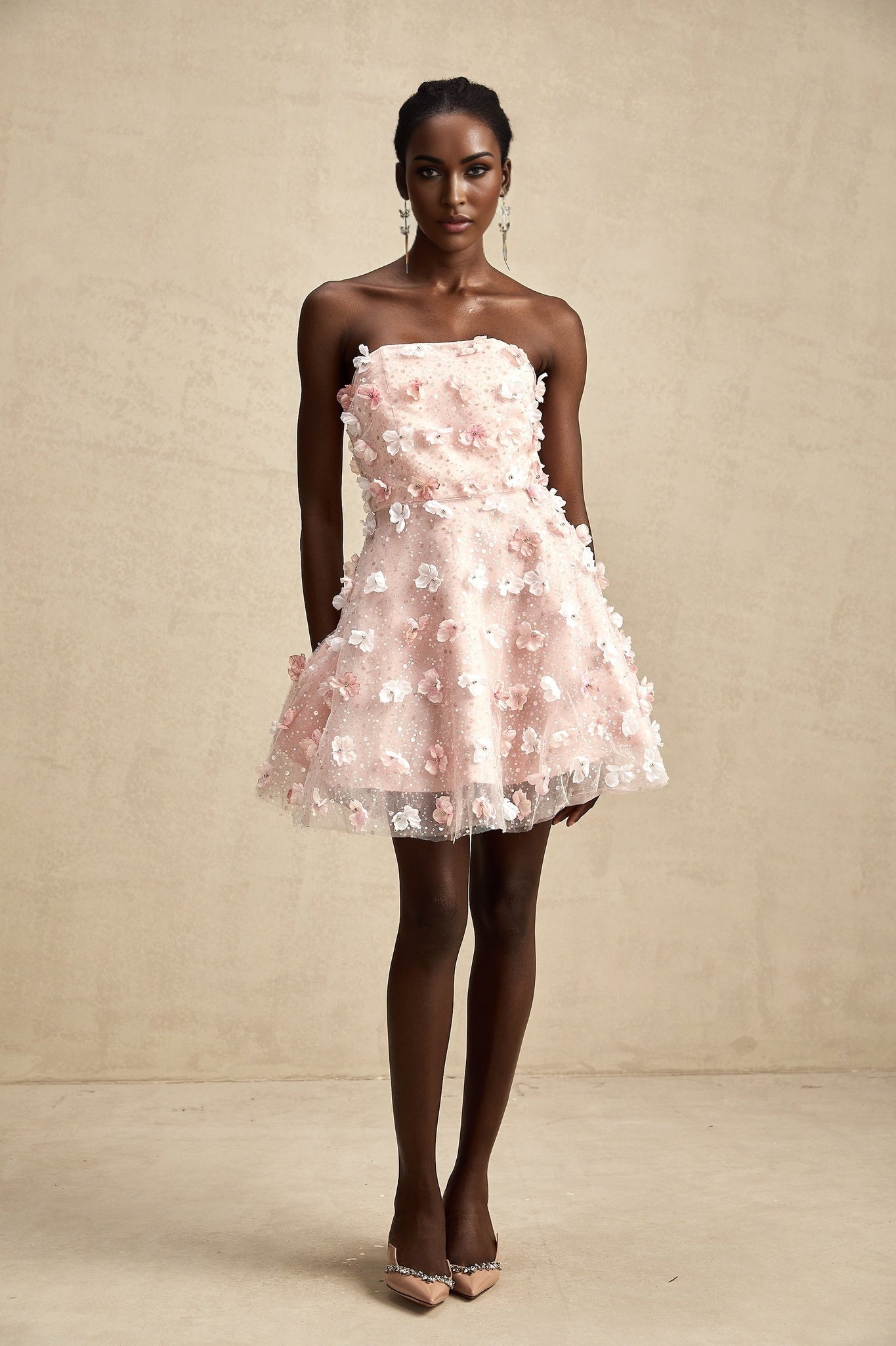 A short puffy mini dress with threedimensional petal details covering the fabric creating a textured floral appearance