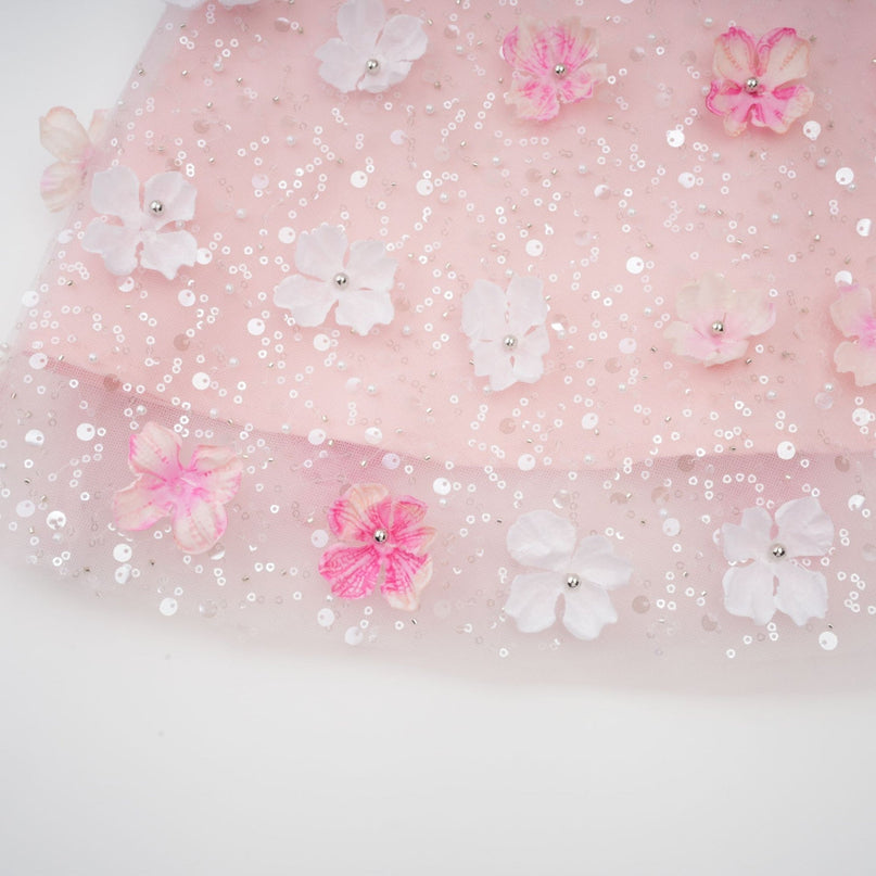 A short puffy mini dress with threedimensional petal details creating a textured floral appearance throughout the garment