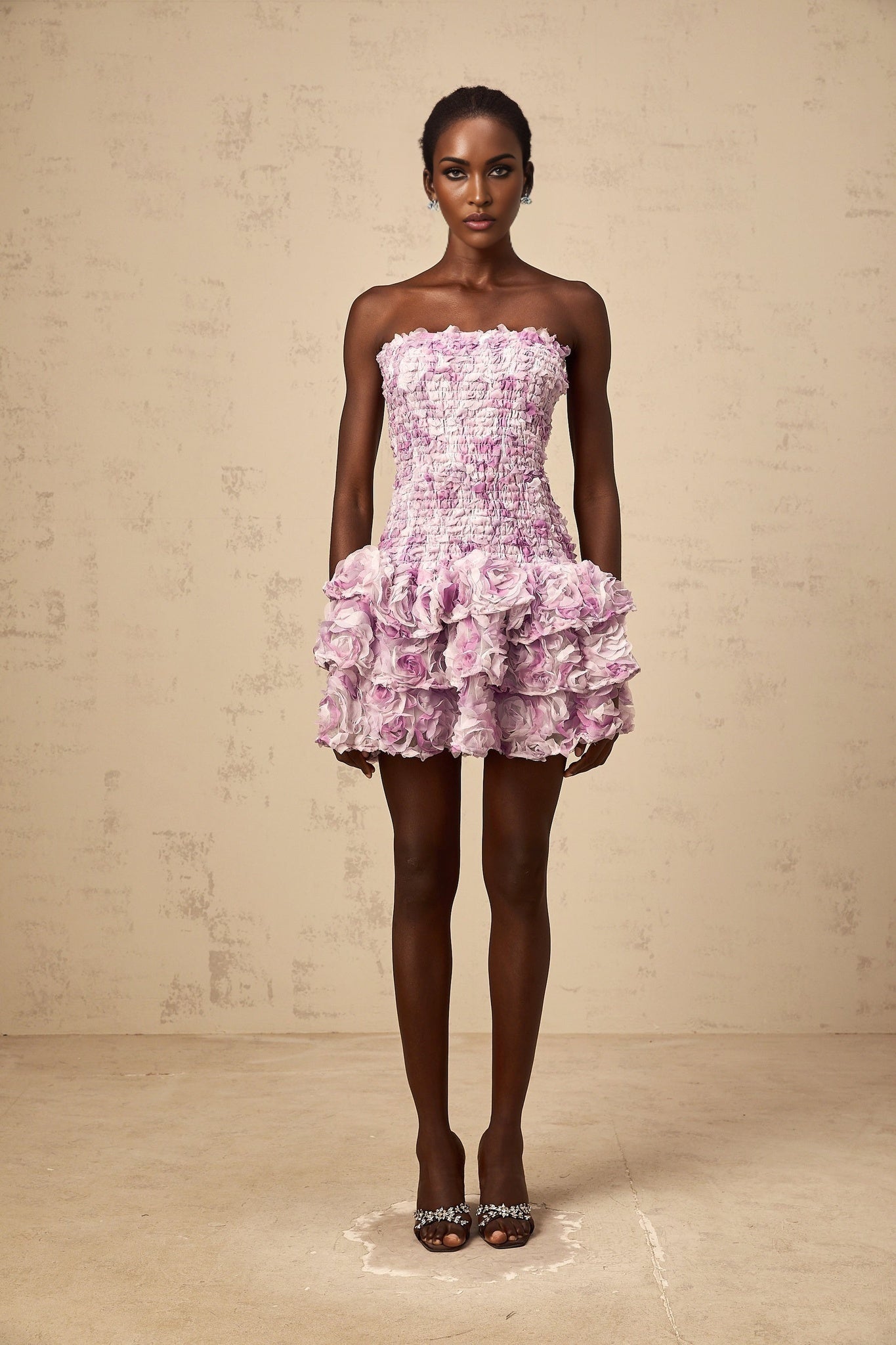 A short purple mini dress with tiered layers of tulle fabric featuring three dimensional petal details throughout creating a floral textured appearance
