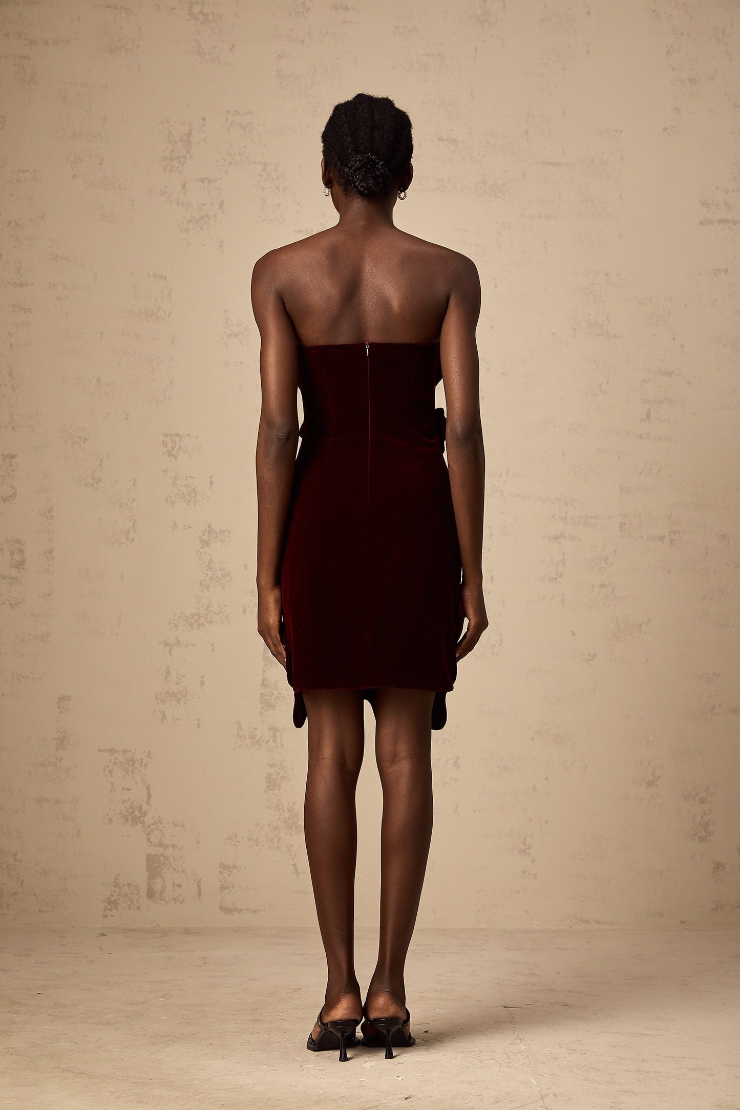 A short red velvet mini dress with floral appliques adorning the fabric