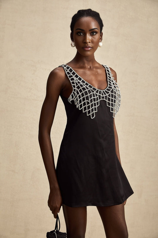 A short satin mini dress in a light color adorned with crystal embellishments elegant formal wear with a feminine silhouette