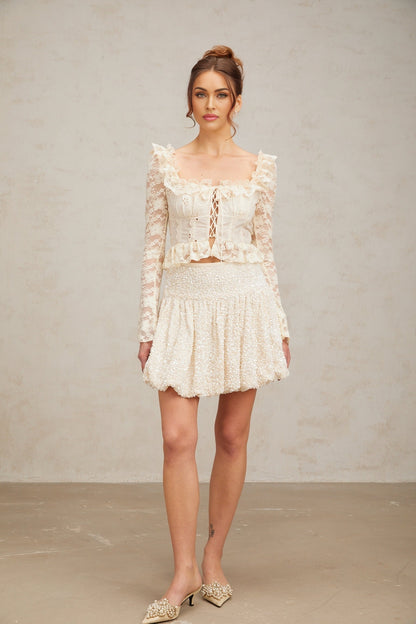 A short shimmering mini skirt with pleats and allover sequin embellishment in a metallic finish