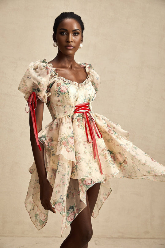 A short sleeveless dress with a floral print pattern layered tulle skirt and tie up detail at the waist