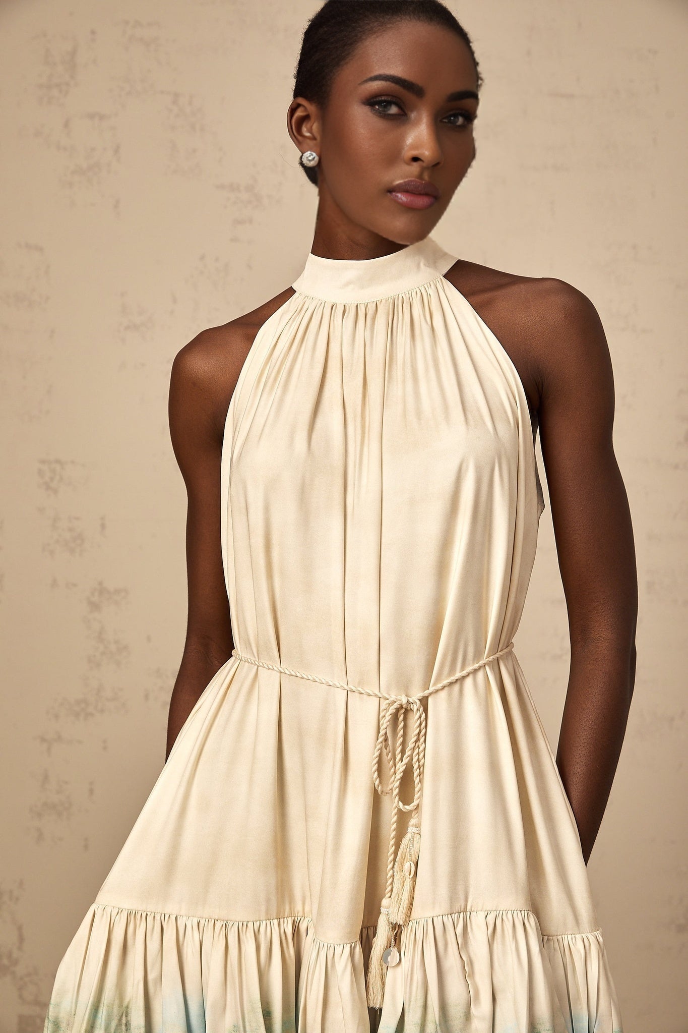 A short sleeveless mini dress with multiple layered tiers featuring a mixed pattern print in various colors