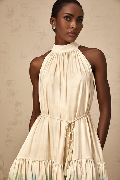 A short sleeveless mini dress with multiple layered tiers featuring a mixed pattern print in various colors