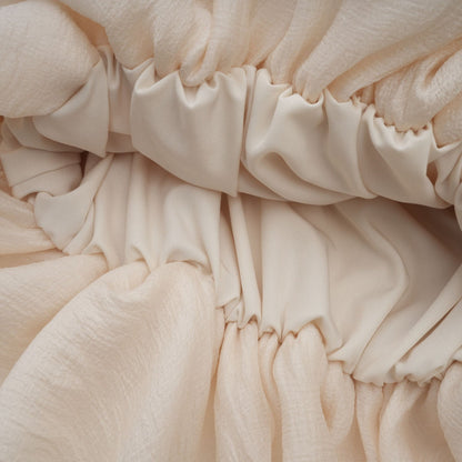 A short tiered mini dress in neutral tones featuring delicate floral applique details named Zephyrine