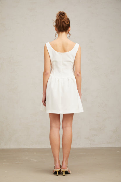 A short white mini dress adorned with crystal embellishments featuring a fitted silhouette and shimmering details
