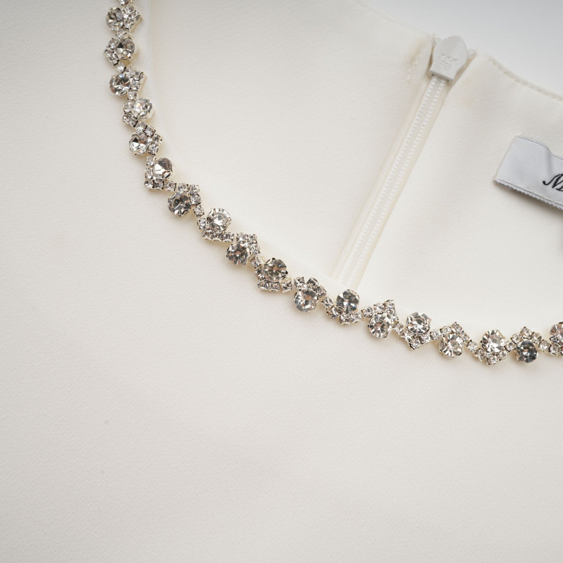 A short white mini dress adorned with crystal embellishments featuring a stylish design named Berenice