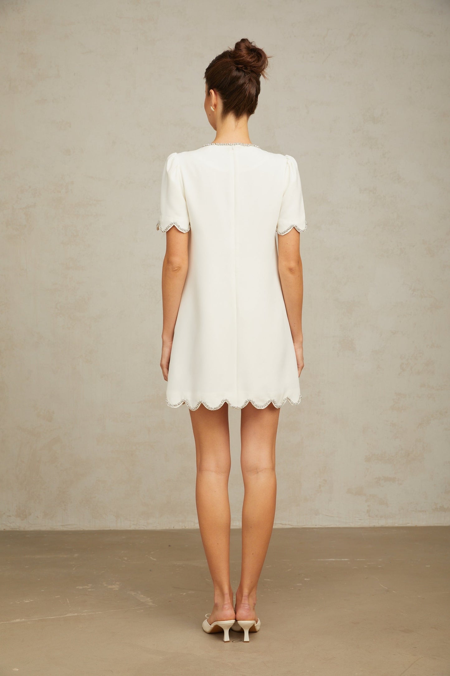 A short white mini dress adorned with crystal embellishments named Berenice