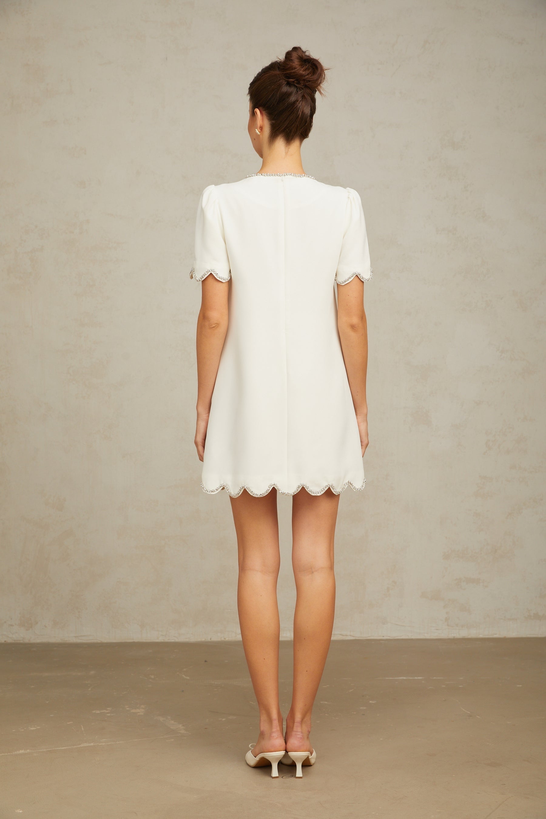 A short white mini dress adorned with crystal embellishments named Berenice