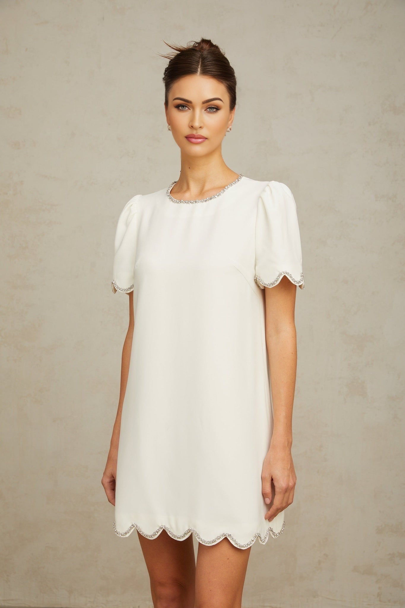 A short white mini dress adorned with crystal embellishments named Berenice