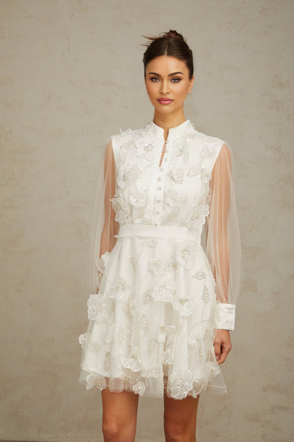 A short white mini dress with 3D floral petal details made of tulle fabric named Camille