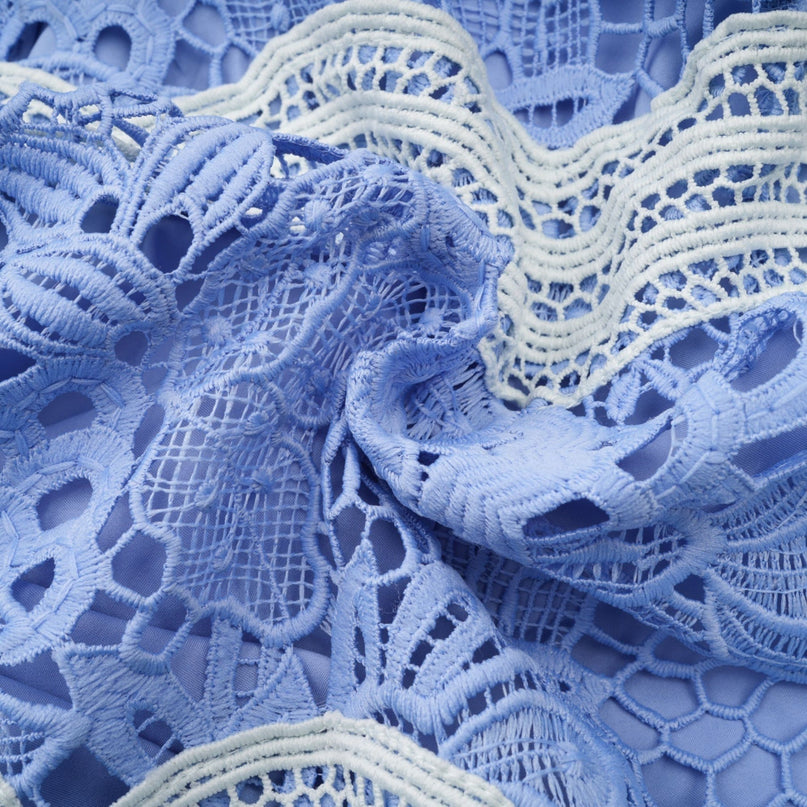 A short white mini dress with a Vneck and colorful floral embroidery featuring a fitted bodice and flared skirt