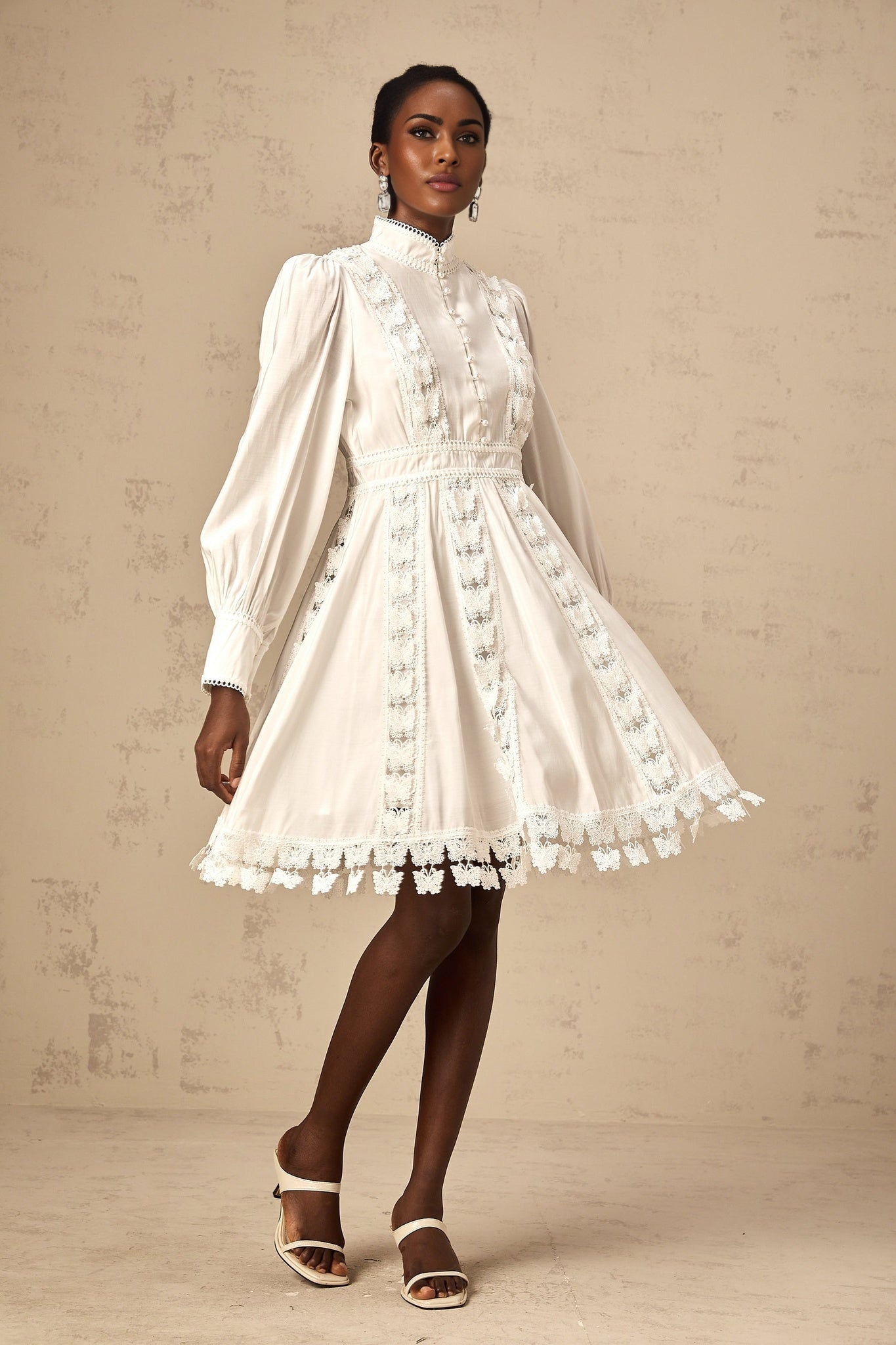 A short white mini dress with butterfly appliqués decorating the fabric