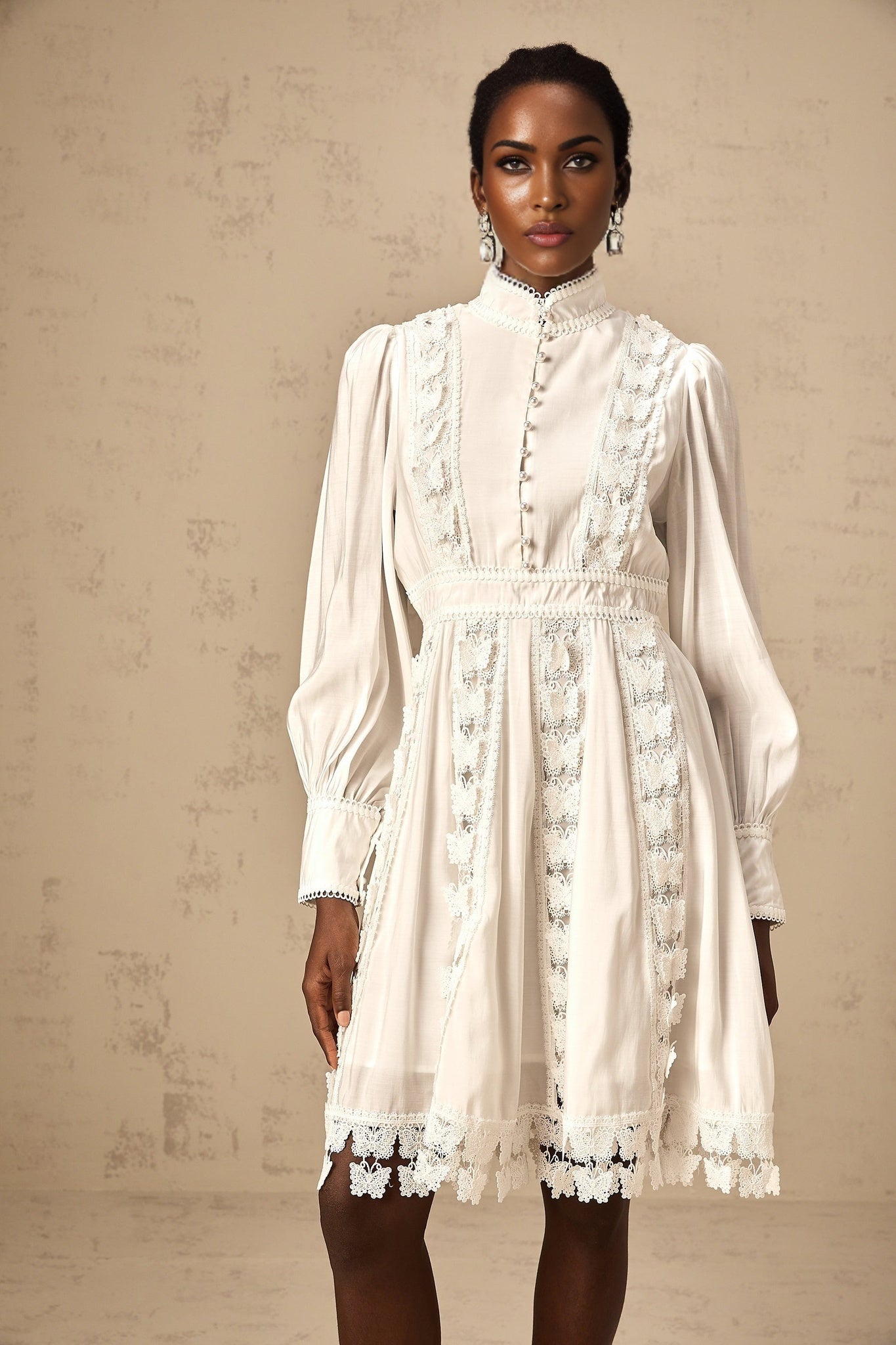 A short white mini dress with butterfly appliques decorating the fabric