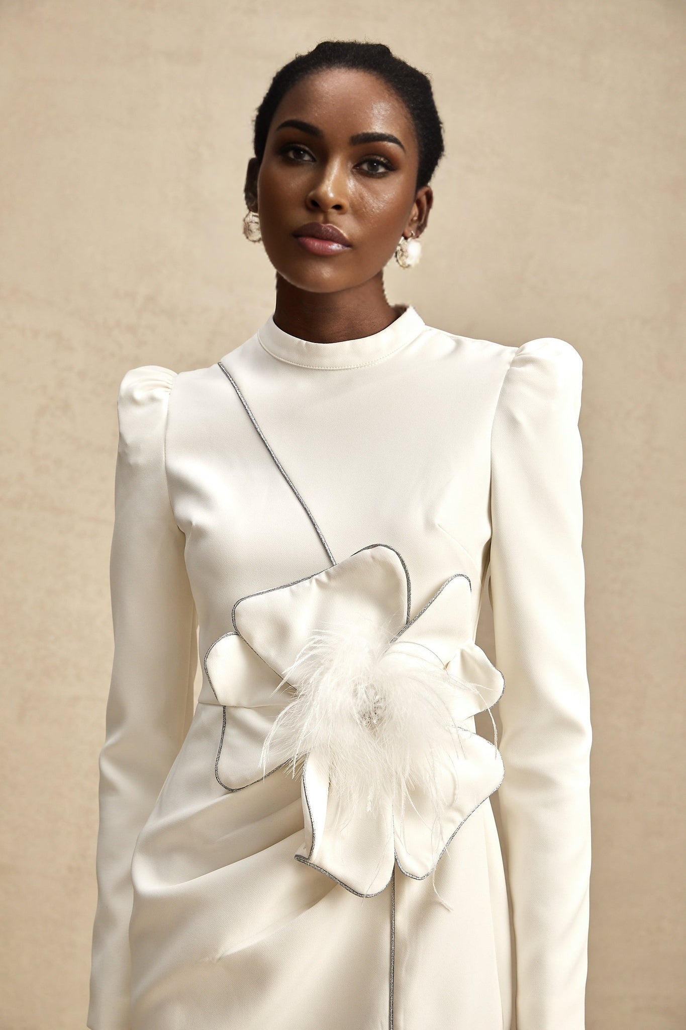 A short white mini dress with decorative artificial flowers adorned on the fabric