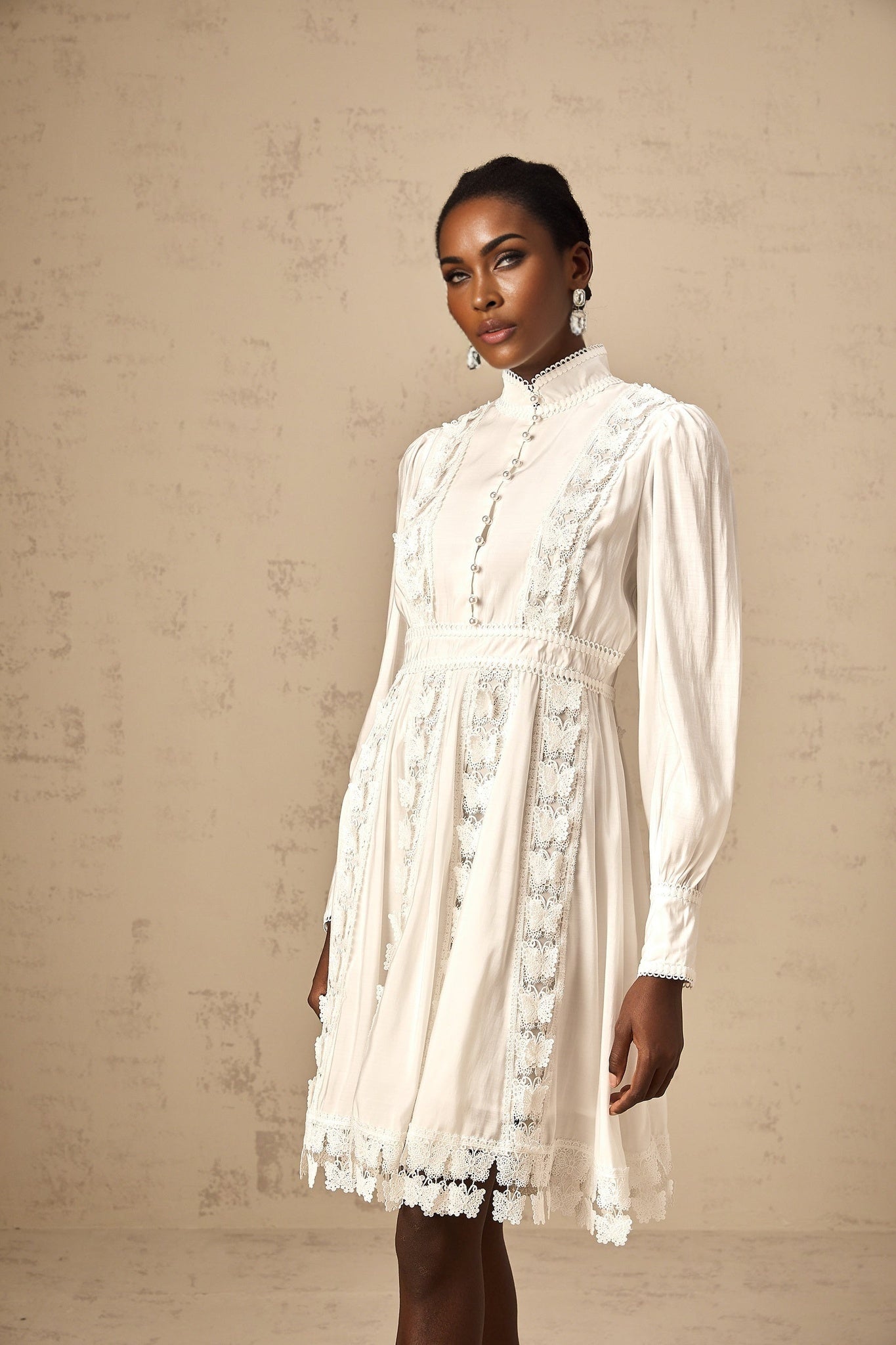 A short white mini dress with decorative butterfly appliques