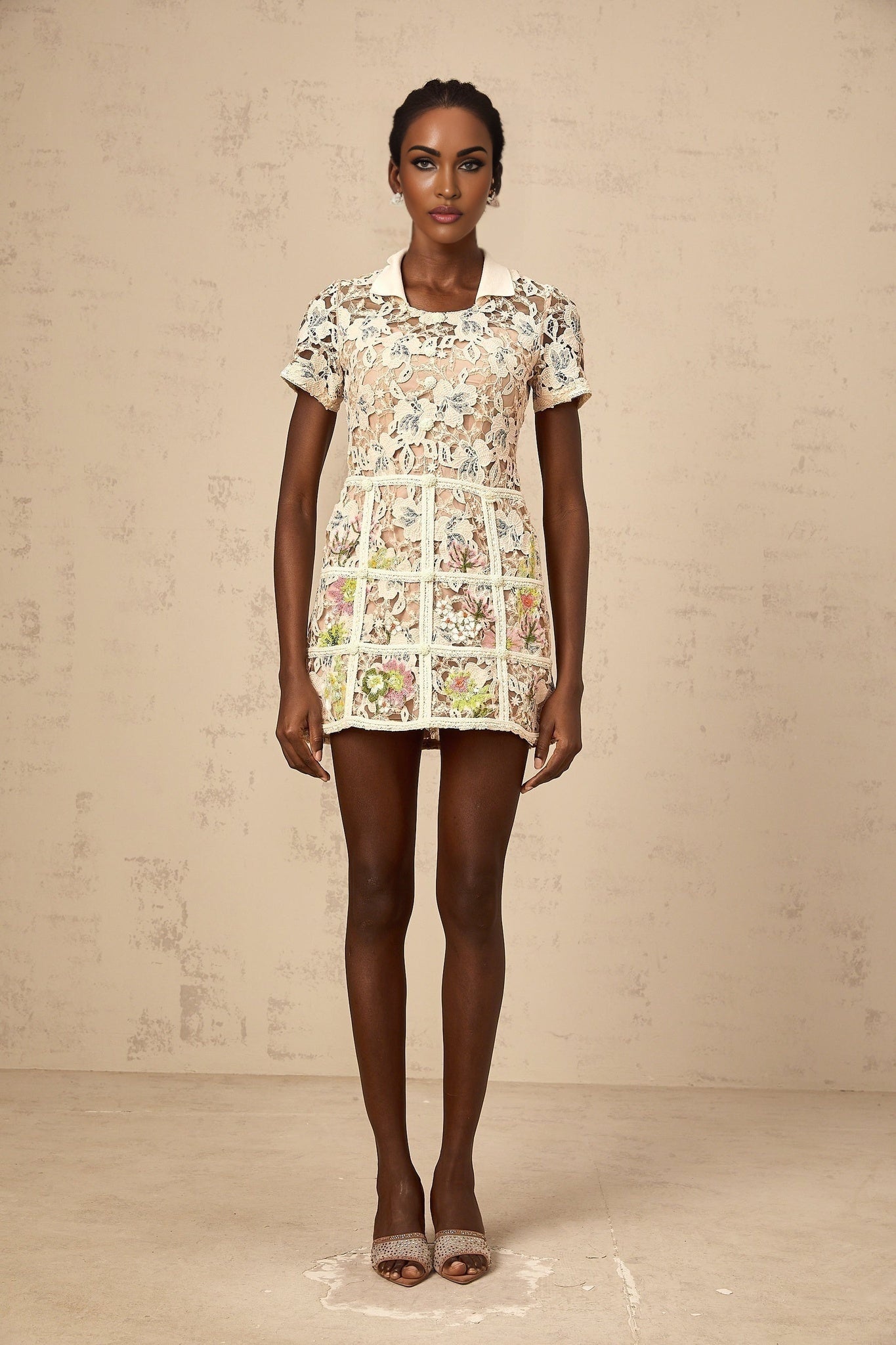 A short white mini dress with delicate floral embroidery featuring a feminine and romantic design