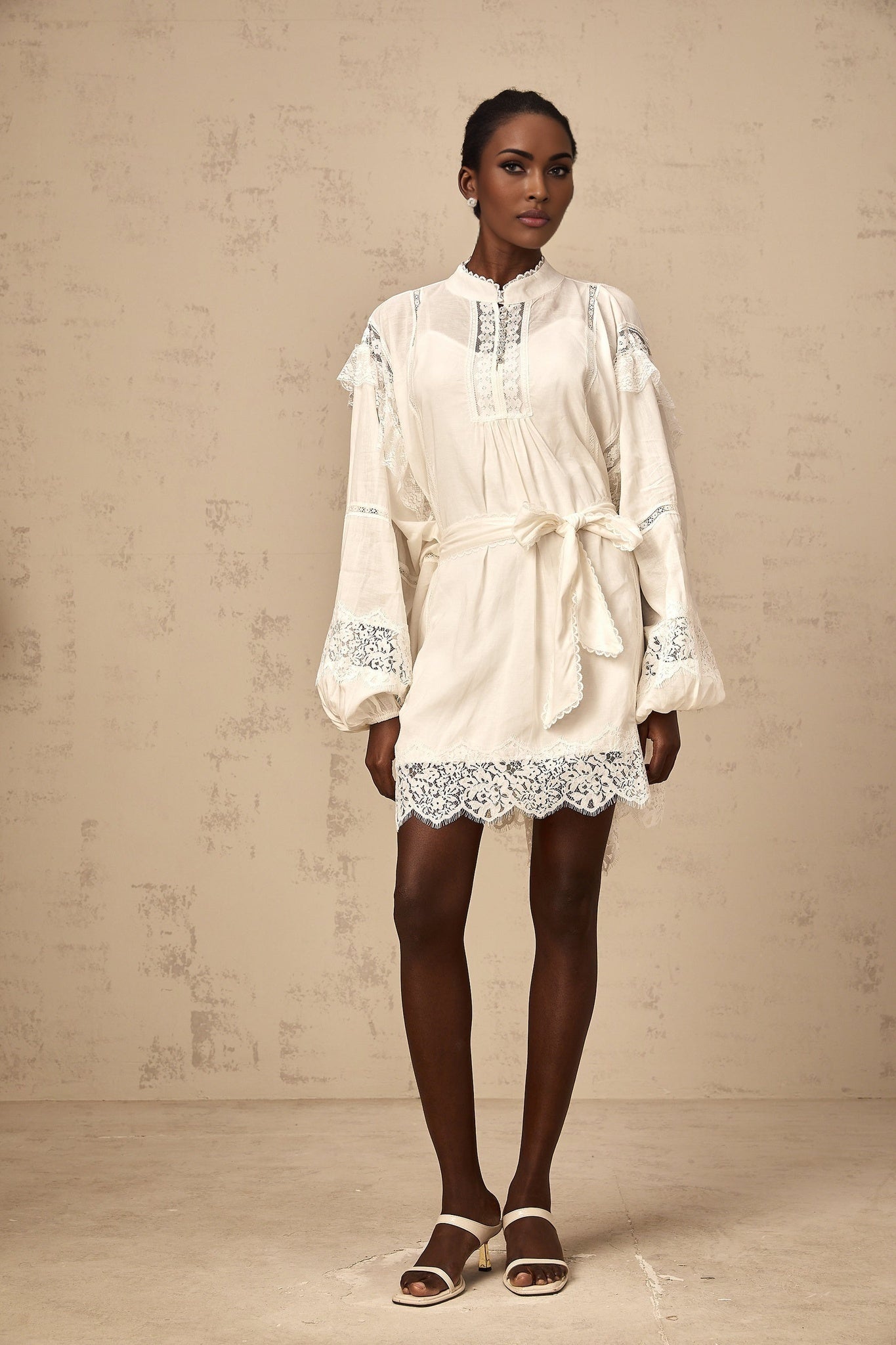 A short white mini dress with floral lace trim details