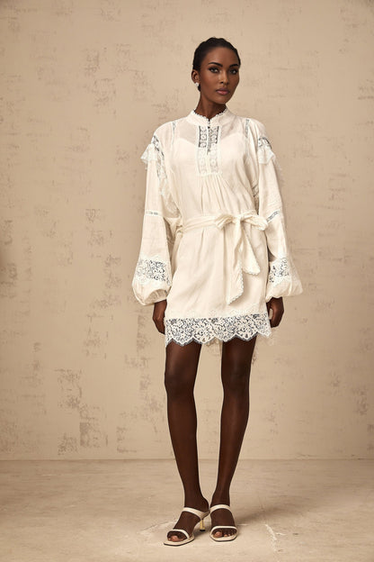 A short white mini dress with floral lace trim details