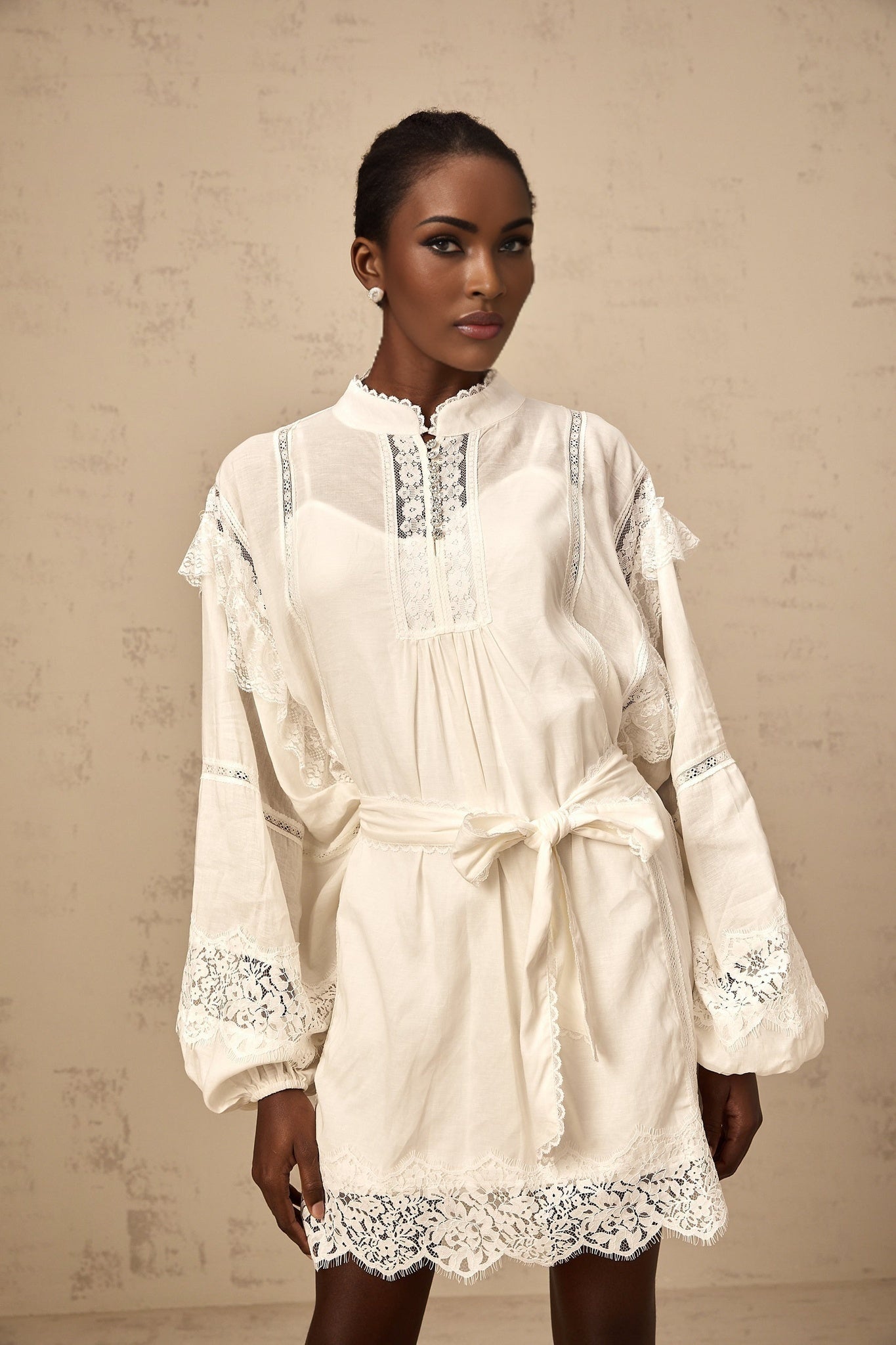 A short white mini dress with floral lace trim details