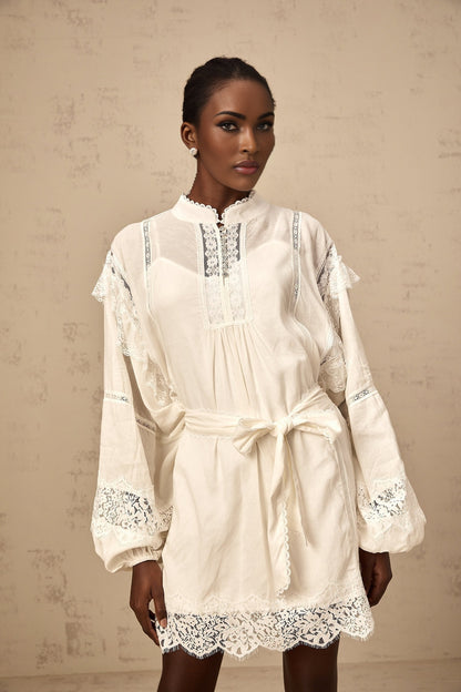 A short white mini dress with floral lace trim details