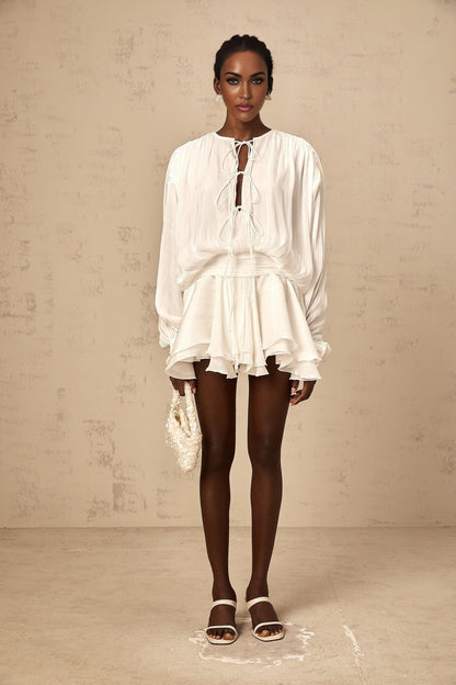 A short white mini dress with pleated fabric and glitter effect named Mahault featuring a sleeveless design and flared skirt