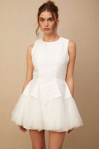 A short white mini dress with puff sleeves and tulle panels featuring a fitted bodice and flared skirt