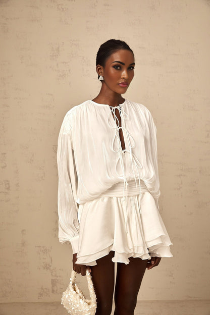 A short white pleated mini dress with a glittery shimmering effect named Mahault