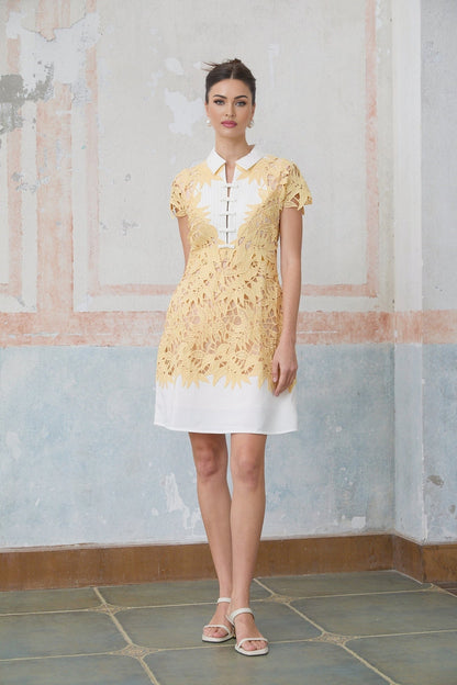 A short yellow mini dress with decorative leaf appliques adorning the fabric