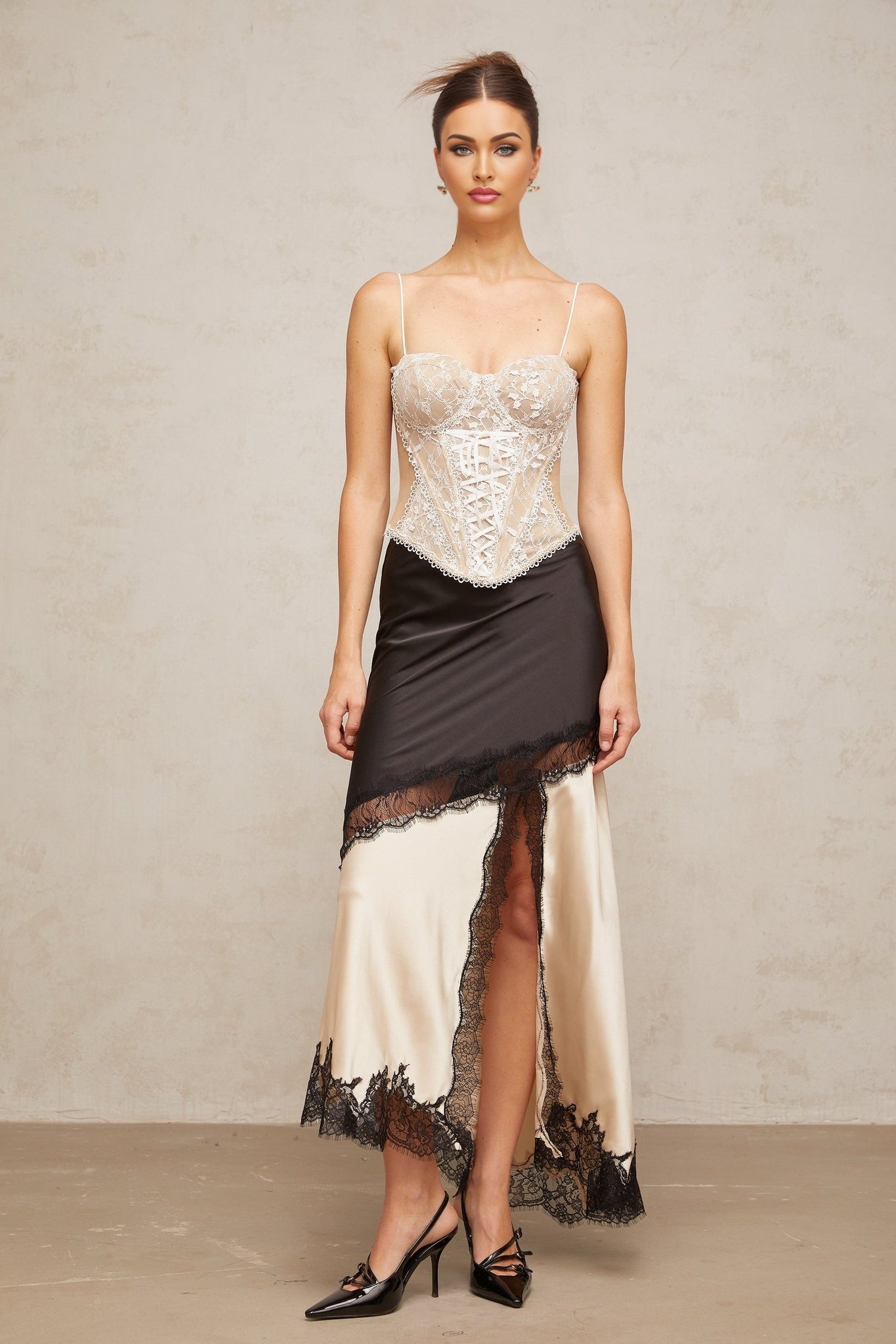 A sleek asymmetric satin skirt with delicate lace panels featuring a feminine design and elegant drape