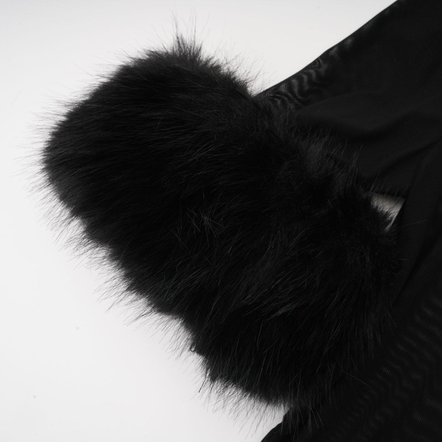 A sleeveless black top with a faux fur bodice and sheer tulle overlay creating a luxurious and elegant look