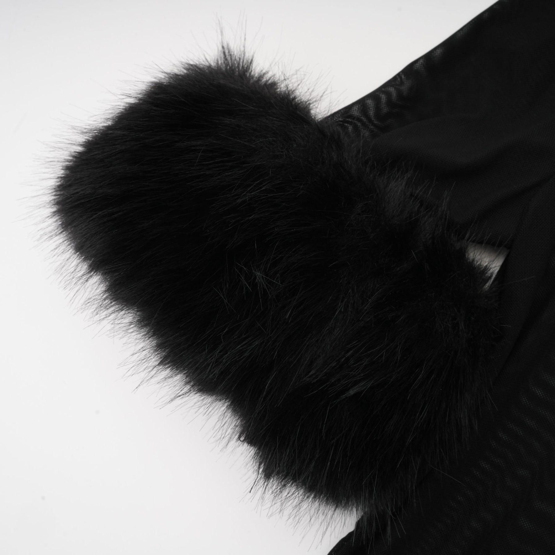 A sleeveless black top with a faux fur bodice and sheer tulle overlay creating a luxurious and elegant look