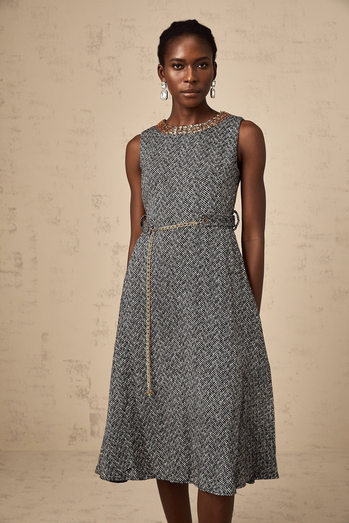 A sleeveless grey tweed midi dress with crystal embellishments suitable for Valentines Day featuring a fitted silhouette and textured fabric
