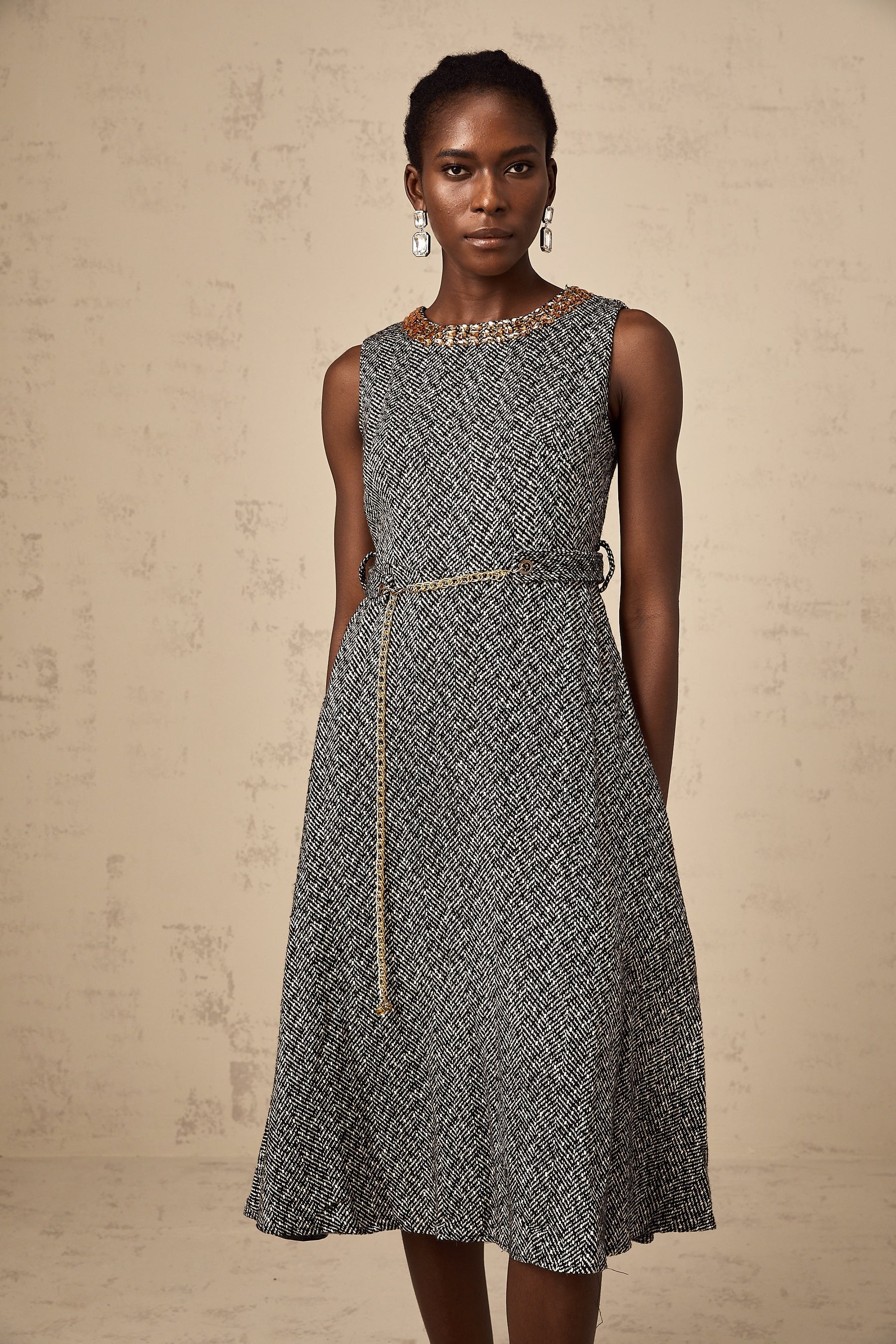 A sleeveless grey tweed midi dress with crystal embellishments suitable for Valentines Day featuring a fitted silhouette and textured fabric