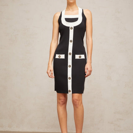 A sleeveless knit mini dress with a halter neckline featuring color blocks in different shades The dress has a form fitting silhouette and falls above the knee