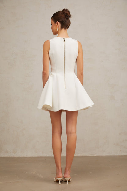 A sleeveless mini dress with a pleated peplum hem named Elise featuring a fitted bodice and flared skirt