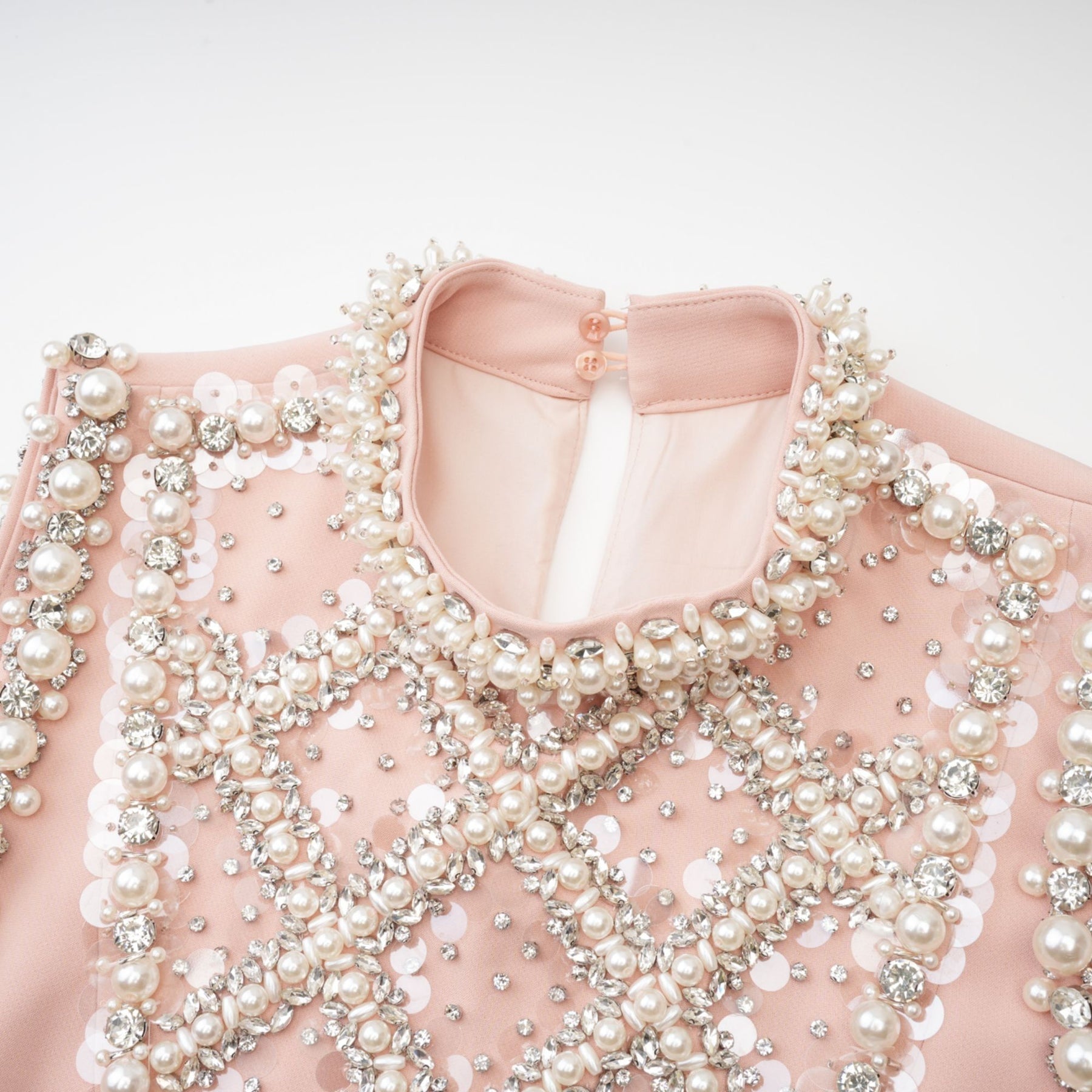 Sleeveless pink dress with crystal and faux pearl embellishments round neckline button fastening thigh length 80% Polyester 20% Cotton