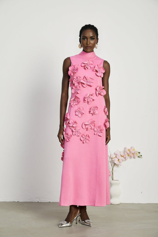 A sleeveless pink maxi dress with a bow and decorative artificial flowers named Magali