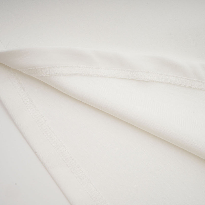 A sleeveless white maxi dress with a bow detail and decorative artificial flowers named Magali