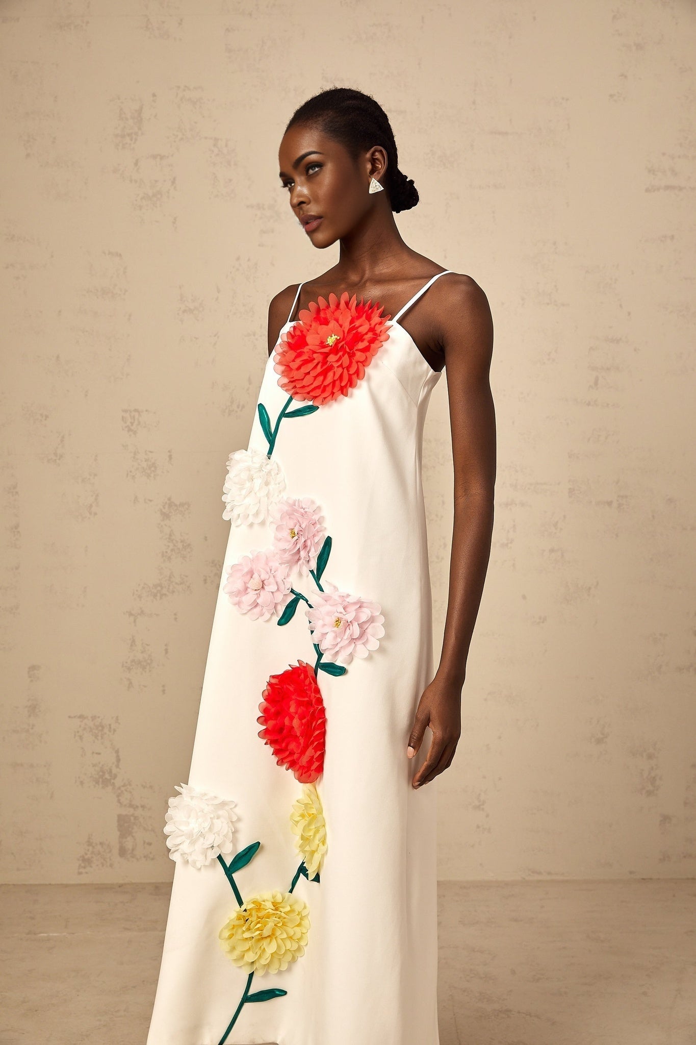 A sleeveless white midi dress with 3D petal details featuring a design by Veronique