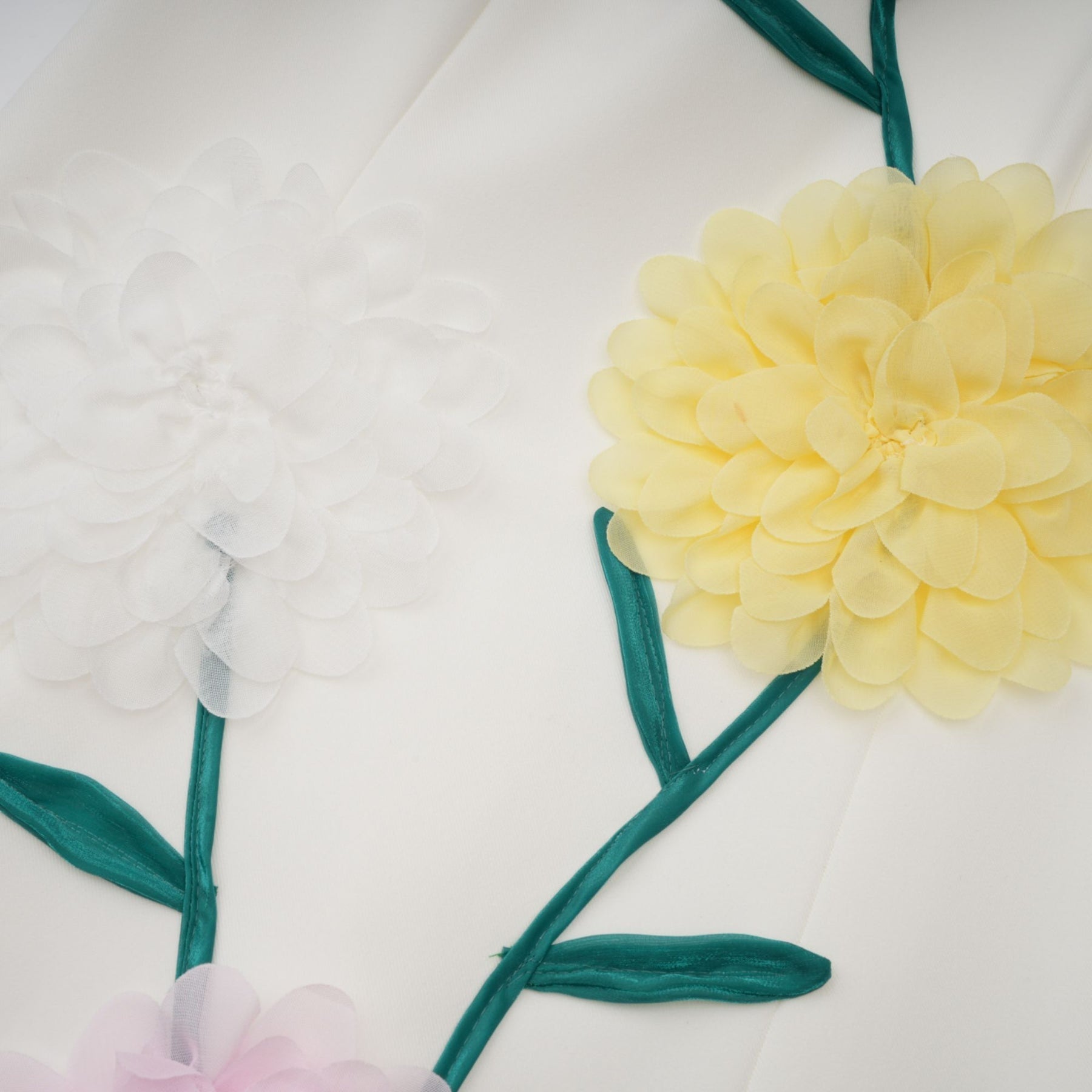 A sleeveless white midi dress with 3D petal details on the bodice