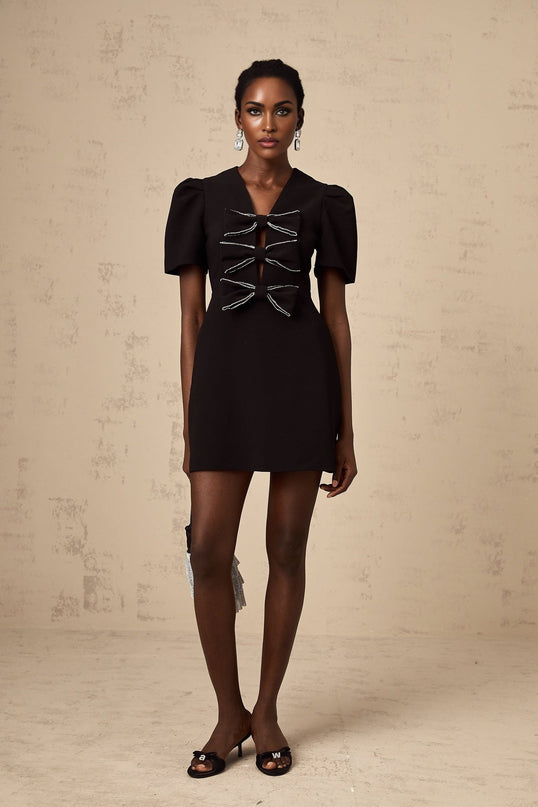 A small black mini dress with a decorative bowknot embellishment