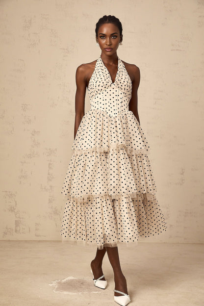 A tiered midi dress in ivory fabric with polka dot pattern featuring multiple layers and a flowy silhouette