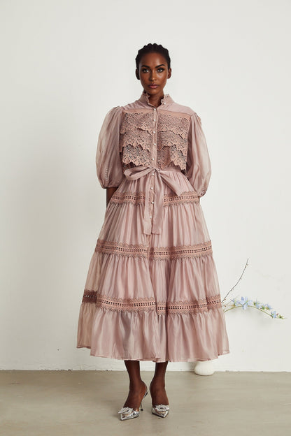 A tiered midi dress with lace detailing and cut out sections featuring a feminine silhouette in a delicate design