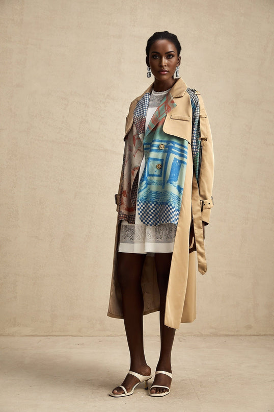 A trench coat with contrasting colors and a printed design featuring a belt cinched at the waist named Josephine