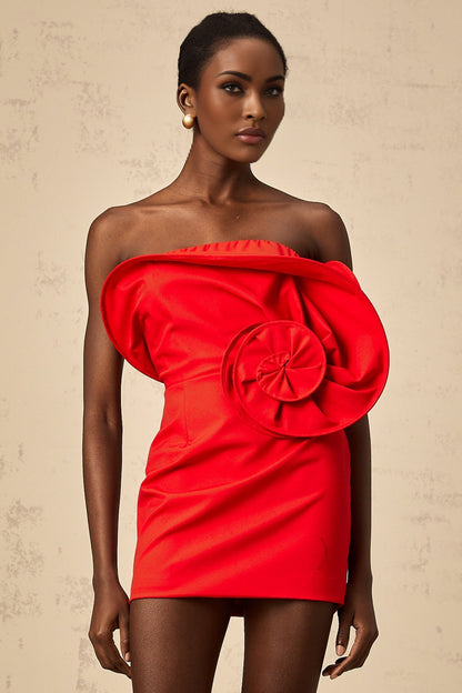 A vibrant red mini dress with an offshoulder neckline featuring a large sculptural rose detail on the bodice creating a romantic and eyecatching silhouette