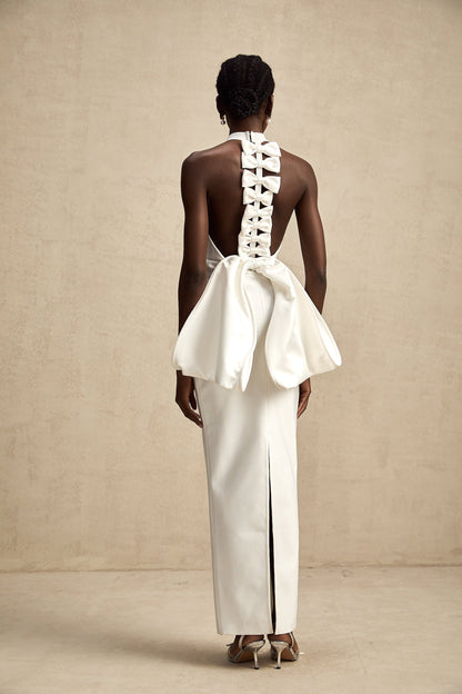 A white bandage dress with an oversized bow accent named Capucine featuring a formfitting silhouette and exaggerated bow detail