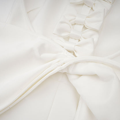 A white bandage dress with an oversized bow detail featuring a fitted silhouette and a capucine style design
