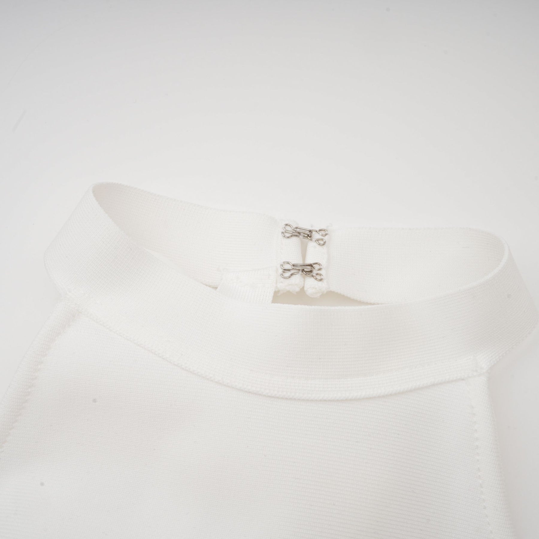 A white bandage dress with an oversized bow detail featuring a fitted silhouette and Capucine style